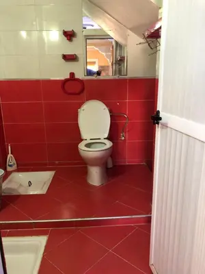 a red bathroom with a toilet and a tub at Mahmoud moulay Yacoub 1 in Moulay Yacoub