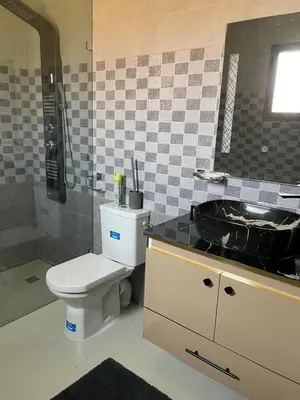 a bathroom with a toilet and a sink at Villas Près De Chez Vous in Amezrou