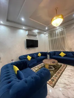 a living room with blue couches and a tv at Villas Près De Chez Vous in Amezrou