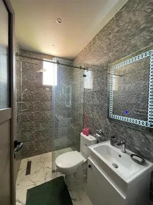 a bathroom with a toilet and a sink and a shower at Villas Près De Chez Vous in Amezrou