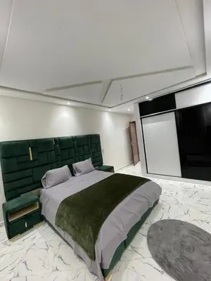a bedroom with a large bed with a green headboard at Villas Près De Chez Vous in Amezrou