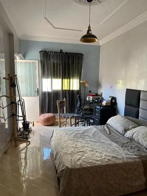 a bedroom with a bed and a desk in it at Fez Room in Fès