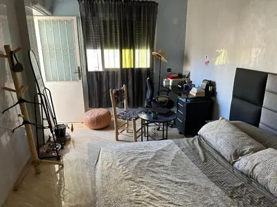 a bedroom with a bed and a desk and a window at Fez Room in Fès