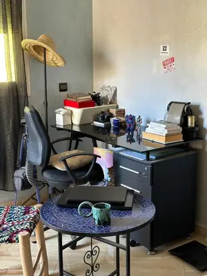 a room with a desk and a table with a coffee mug at Fez Room in Fès