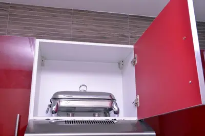 a kitchen with a silver appliance in a red cabinet at Appartement duplex très chic in Ville Nouvelle