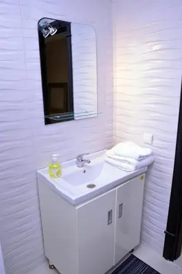 a white bathroom with a sink and a mirror at Appartement duplex très chic in Ville Nouvelle