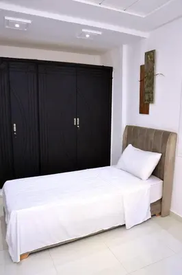 a bedroom with a bed with black cabinets at Appartement duplex très chic in Ville Nouvelle