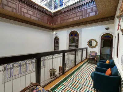 a room with a balcony with chairs and a ceiling at Riad d'Art de Fès in Fès al Bali