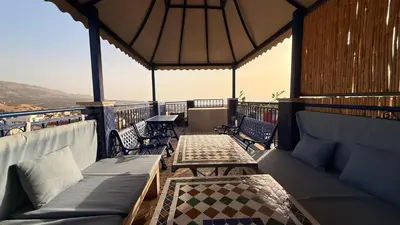 a balcony with couches and tables and a view at Riad d'Art de Fès in Fès al Bali