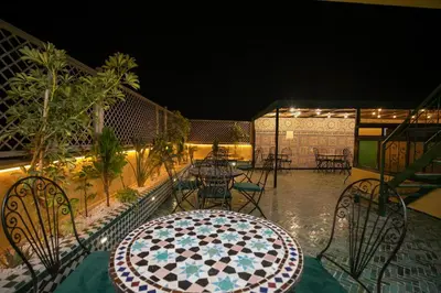 a table and chairs on a patio at night at Dar Golden Ziat in Fès
