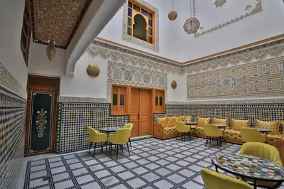 a restaurant with yellow chairs and tables in a room at Dar Golden Ziat in Fès