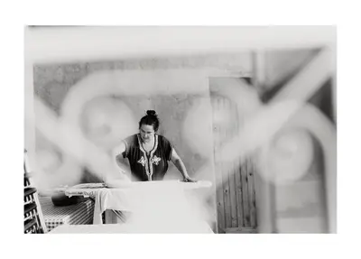a woman is working on a table in a room at Khamlia Desert Bed & Breakfast in Khamliya