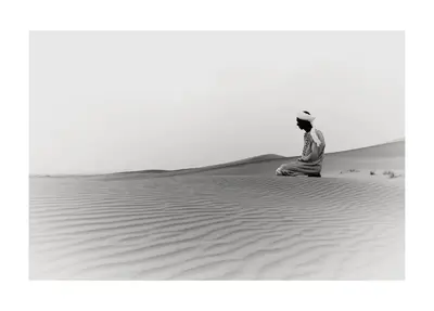 a man sitting in the desert at Khamlia Desert Bed & Breakfast in Khamliya