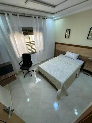 a bedroom with a bed and a chair and a window at appartement à fes in Fès