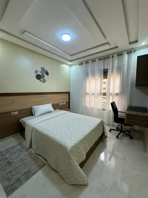 a bedroom with a bed and a desk at appartement à fes in Fès