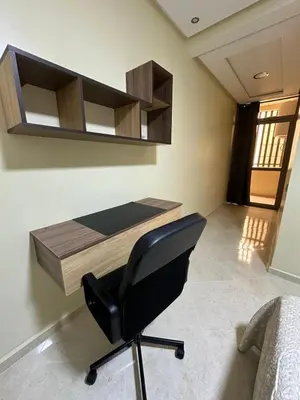 a desk with a black chair in a room at appartement à fes in Fès