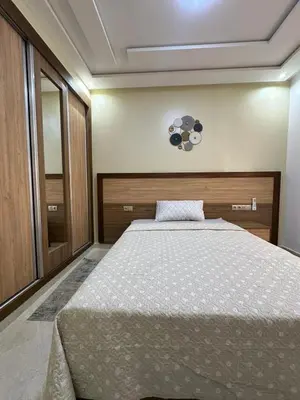 a bedroom with a bed and a mirror at appartement à fes in Fès