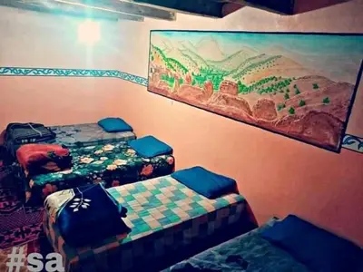 a room with two beds and a painting on the wall at Taghia Accommodation in Taghia