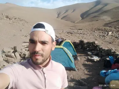 a man standing in front of a tent in the desert at Taghia Accommodation in Taghia