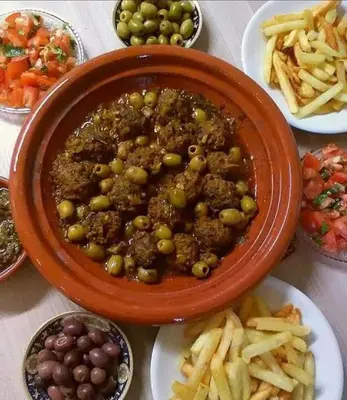 a bowl of food with olives and fries on a table at Taghia Accommodation in Taghia