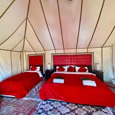 a bedroom with two beds in a tent at Luxury Camp Glamping in Merzouga