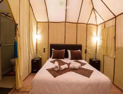 a bedroom with a bed with two stuffed animals on it at Luxury Camp Glamping in Merzouga