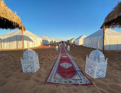 a red carpet on the beach with tents at Luxury Camp Glamping in Merzouga
