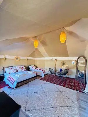 a bedroom in a tent with a bed and a mirror at Luxury Camp Glamping in Merzouga