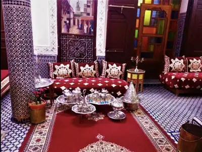 a living room with a red couch and a red rug at Chambres d'Hôtes Hayat in Dar Mahres