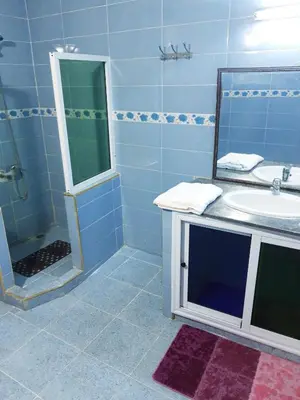a blue bathroom with a sink and a mirror at Chambres d'Hôtes Hayat in Dar Mahres