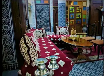 a living room with a red couch and a table at Chambres d'Hôtes Hayat in Dar Mahres