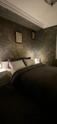 a bedroom with a bed and two pictures on the wall at Nice appartement au centre de IFRANE in Ifrane
