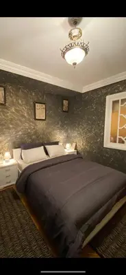 a bedroom with a large bed and a chandelier at Nice appartement au centre de IFRANE in Ifrane