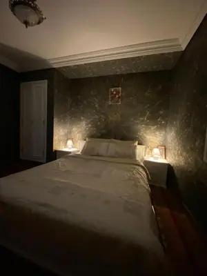 a bedroom with a bed with two lights on it at Nice appartement au centre de IFRANE in Ifrane