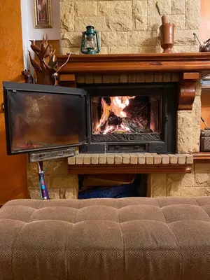 a fireplace with a tv and a fire in it at Nice appartement au centre de IFRANE in Ifrane
