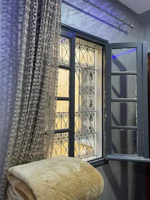 a room with a window and a stool in front at Logement bien placé in Meknès