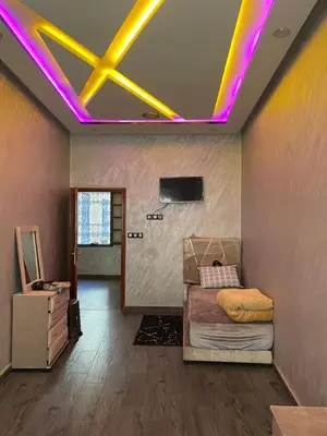 a room with a bed and purple lights on the ceiling at Logement bien placé in Meknès
