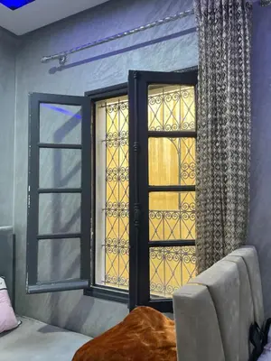 a window in a room with a bed and a curtain at Logement bien placé in Meknès