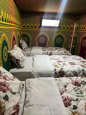 a room with three beds and a wall with patterns at Villa Maroua in Madkhal Meski