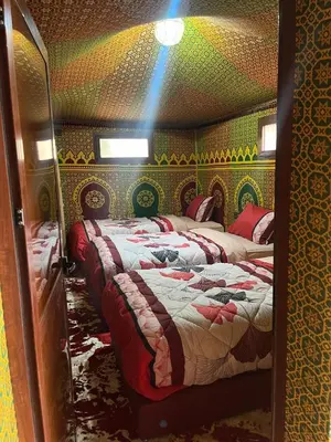 two beds in a room with green and yellow wallpaper at Villa Maroua in Madkhal Meski