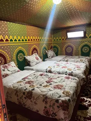 two beds in a room with a wall covered in wallpaper at Villa Maroua in Madkhal Meski