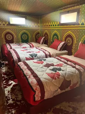 a room with three beds in a room with at Villa Maroua in Madkhal Meski