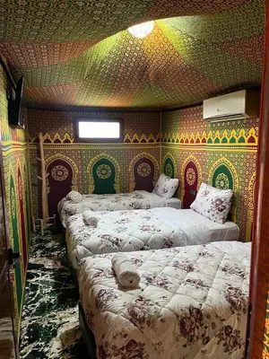 a bedroom with three beds in a room with a wallpaper at Villa Maroua in Madkhal Meski