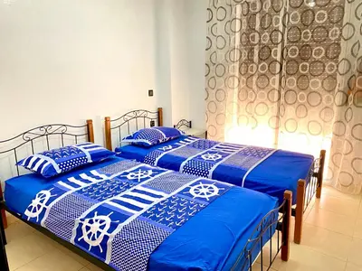 two beds with blue and white blankets and pillows at Mahdi Oussama in Tazelaft