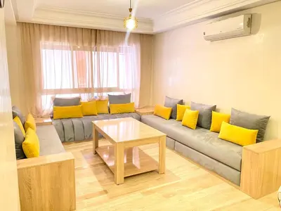 a living room with a couch with yellow pillows at Mahdi Oussama in Tazelaft