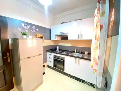 a kitchen with white cabinets and a refrigerator at Mahdi Oussama in Tazelaft