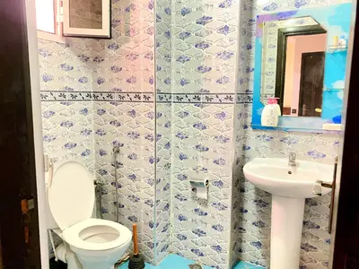 a bathroom with a toilet and a sink at Mahdi Oussama in Tazelaft