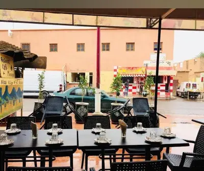 a patio with tables and chairs and a building at Hotel Sahara in Tafrourht nʼAït Bou Jijou