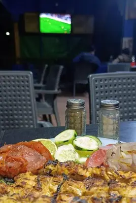 a plate of food with cucumbers and tomatoes on a table at Hotel Sahara in Tafrourht nʼAït Bou Jijou