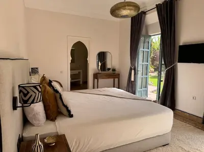 a bedroom with a large bed and a sliding glass door at Villa Blisina - Piscine privée & Petit-déjeuner inclus à Marrakech in Marrakech